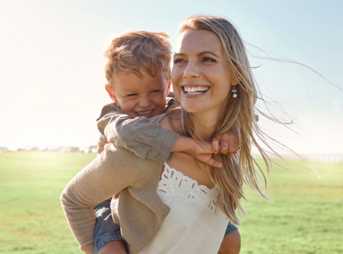 mother smiling with child on her back