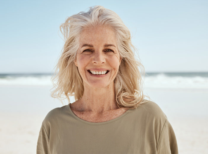 woman smiling with beach in background