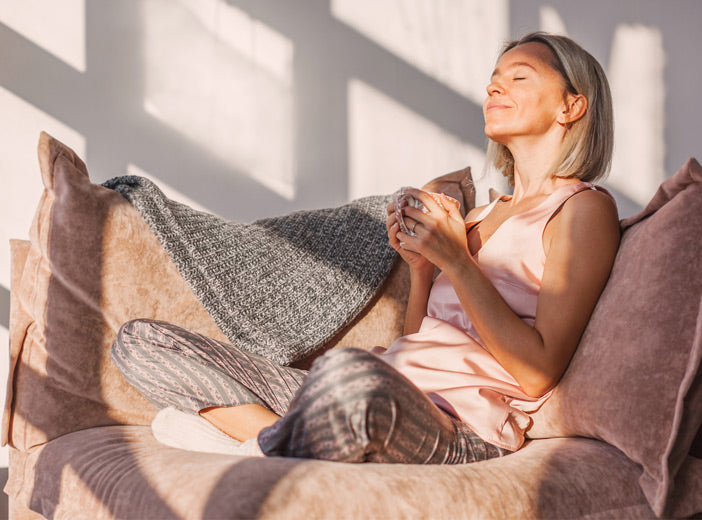 woman sitting on couch with a mug in her hands