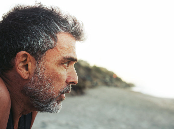 close up of mans face with beach in the background