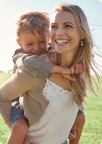 mother smiling with son on her back