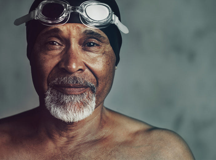 image of mans face with swimming cap and goggle on his head